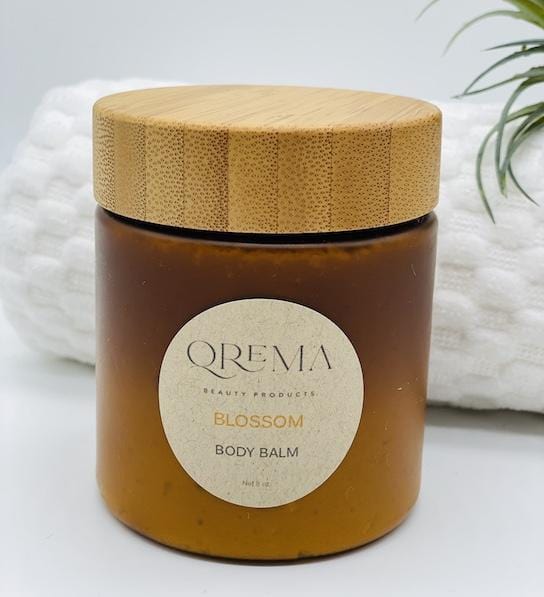 Qrema BLOSSOM Body Balm - Qrema Like Spring in full bloom, our Orange Vanilla bod balm will take you away to your favorite garden where blossoms and warmth fill the air.   Blossom has properties that reduce anxiety and depression, reliefs pain, Anticancer and antioxidant activity.  Ingredients: shea butter, mineral oils, fragrance essential oil and natural powder.  *Contains Tree Nuts  bpa free container bamboo lid.