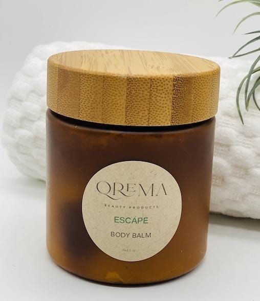 Qrema ESCAPE Body Balm - Qrema Paradise awaits as you escape with our Coconut Lime scented body balm. Wrap yourself in a delightful cocktail of aromas that are sure to take you far, far, away.  Escape has properties that help soothe, relax. It's uplifting and invigorating. It can help clear your mind and encourage mental energy.   Ingredients: shea butter, mineral oils, fragrance essential oil and natural powder.  *Contains Tree Nuts   8 oz bpa free container with bamboo lid.