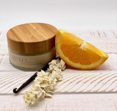 Qrema BLOSSOM Body Balm - Qrema Like Spring in full bloom, our Orange Vanilla bod balm will take you away to your favorite garden where blossoms and warmth fill the air.   Blossom has properties that reduce anxiety and depression, reliefs pain, Anticancer and antioxidant activity.  Ingredients: shea butter, mineral oils, fragrance essential oil and natural powder.  *Contains Tree Nuts 4oz. Glass container bamboo lid.