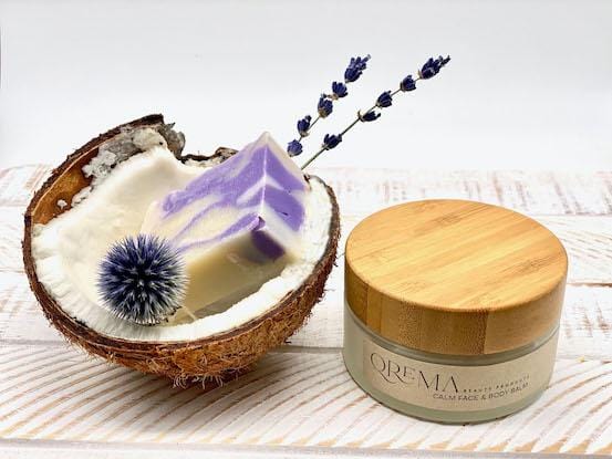 Qrema CALM Face & Body Balm - Qrema Enter a state of heavenly bliss with our Coconut Lavender scented face & body balm. Buttery Coconut softens rough skin and Lavender essence calm the mind and spirit.  Calm has properties that are soothing, relaxing, relieves pain. It can help ease muscles, joint pain, sprains and backache.  Ingredients: shea butter, mineral oils, fragrance essential oil and natural powder.  *Contains Tree Nuts 4 oz glass container with bamboo lid.
